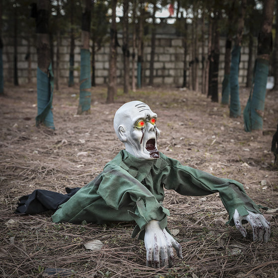 Zombie prop crawling across a forest floor