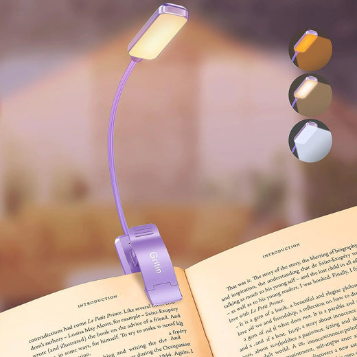 Book light clipped onto the top of an open book, illuminating the page