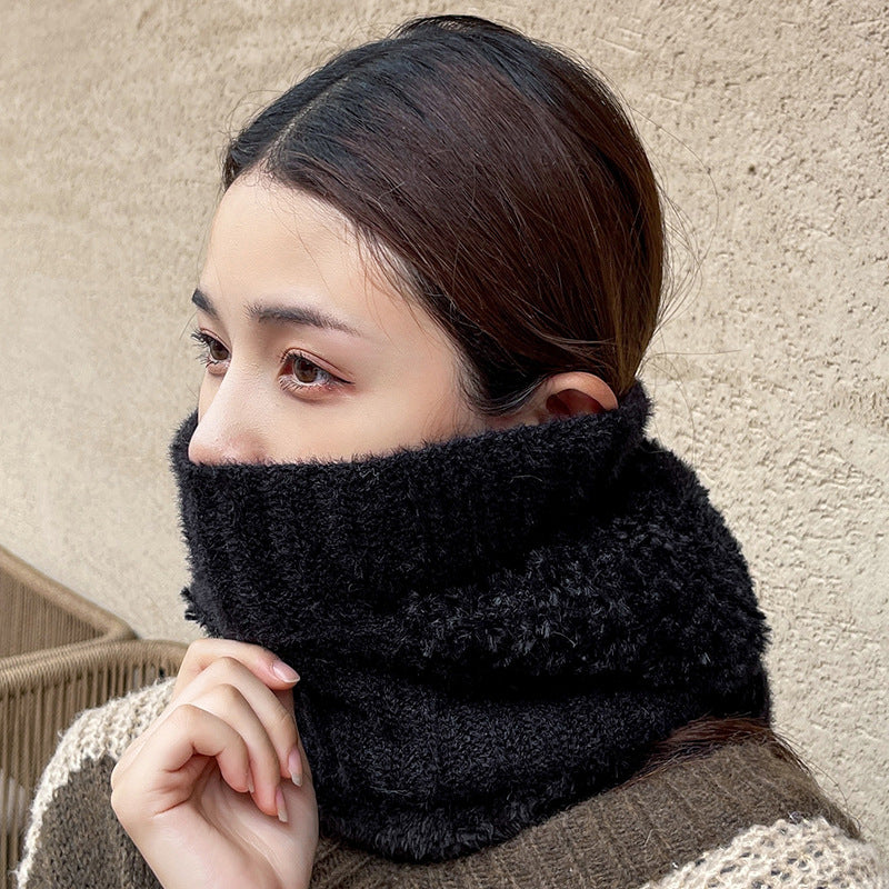 Woman pulling a black knit neck warmer up over her face