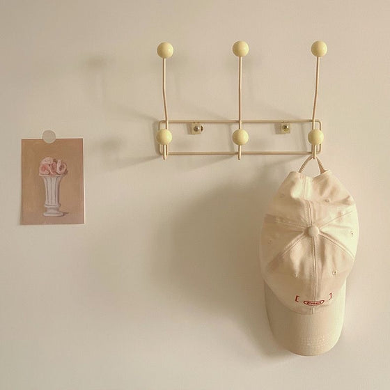 Gold-tone rail hooks holding a cap