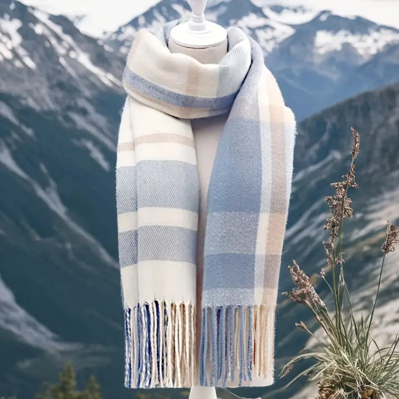 Blue plaid winter tassel scarf on a mannequin with mountain background