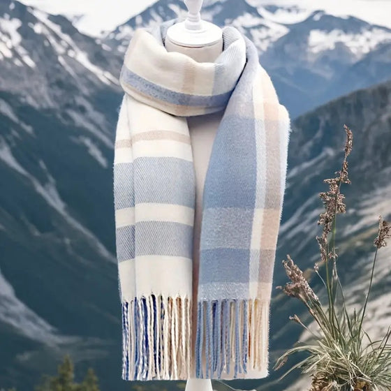 Blue plaid winter tassel scarf on a mannequin with mountain background