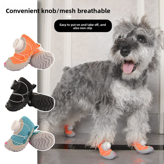 Schnauzer wearing orange mesh dog shoes with knob closures