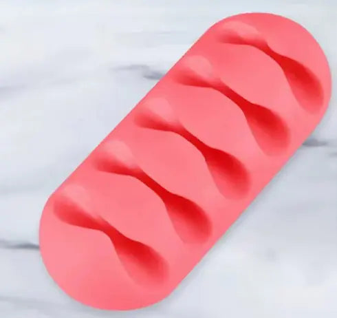 Coral-pink oval silicone base with five wavy molded channels for routing and separating individual cables