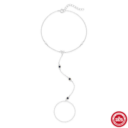 Platinum tone hand chain bracelet with blue marquise stones and attached ring chain