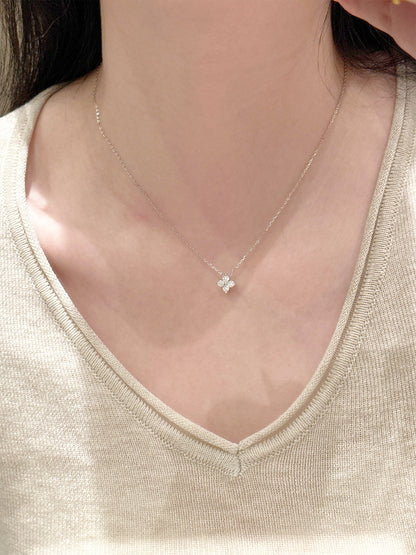 Four-leaf clover pendant necklace worn with a v-neck sweater