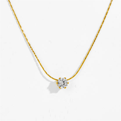 A delicate gold chain necklace with a single round-cut clear gemstone pendant in a gold prong setting, displayed against a clean white background.