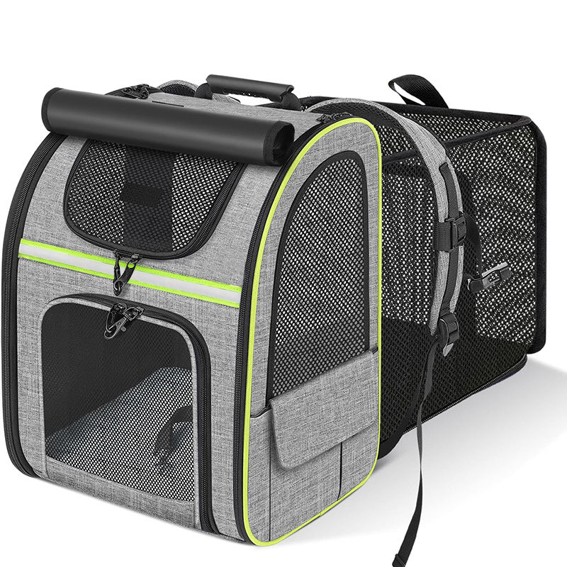 Grey pet carrier backpack with green trim, angled view showing mesh panels and straps