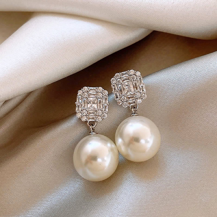Close-up of the silver-tone square zircon cluster with faux pearl drop stud earring