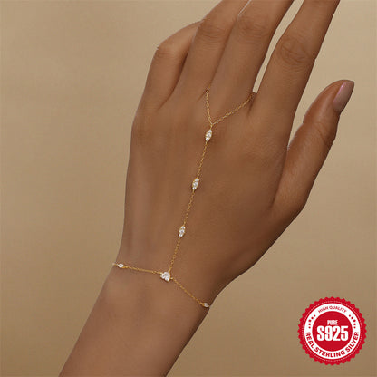 Gold hand chain bracelet worn on the back of the hand with marquise stones from wrist to finger