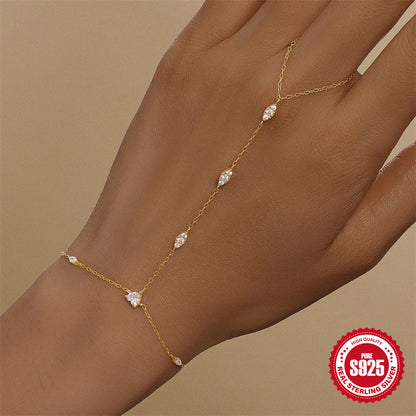 Close up of a gold hand chain with marquise cut stones across the back of the hand