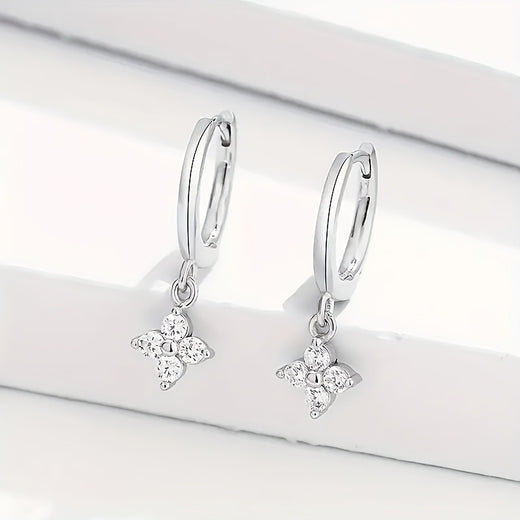 Silver-tone huggie hoop earrings with dangling four-leaf clover charms