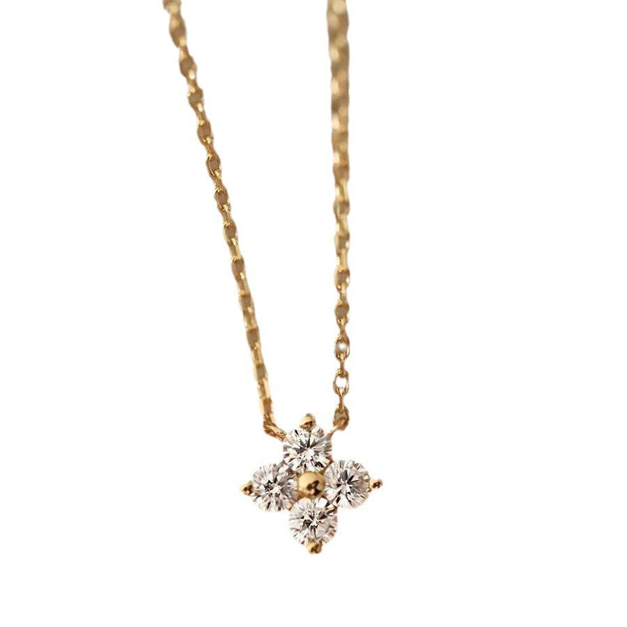 Gold four-leaf clover pendant necklace on a white background