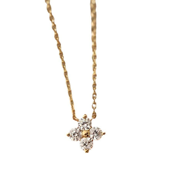 Gold four-leaf clover pendant necklace on a white background
