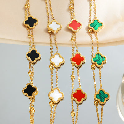 Four-leaf clover charm bracelets in black, white, red, and green, gold-tone chain, all color options shown