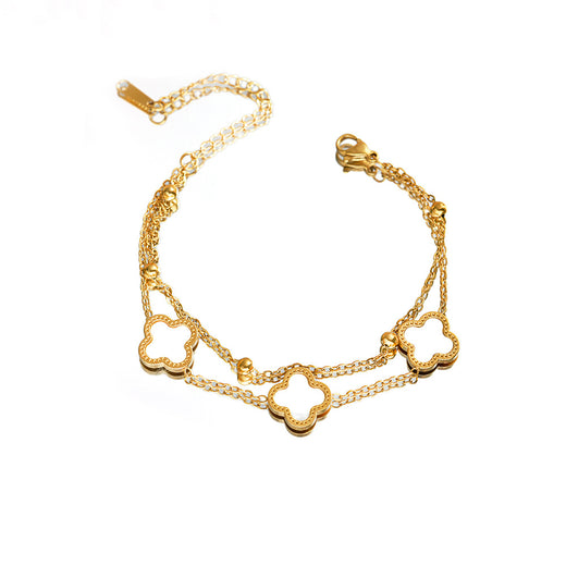 Open four-leaf clover charm bracelet in gold-tone with double chain and lobster clasp, flat lay