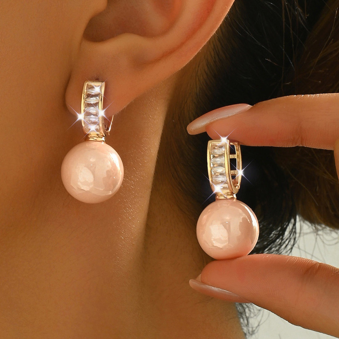 Simple Light Luxury Ear Buckle in pink pearl with crystal pave huggie hoop, close-up on ear
