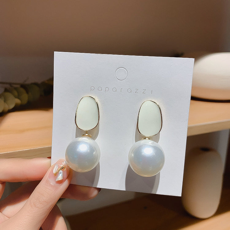 Pair of pink pearl drop stud earrings on jewelry card, silver tone posts