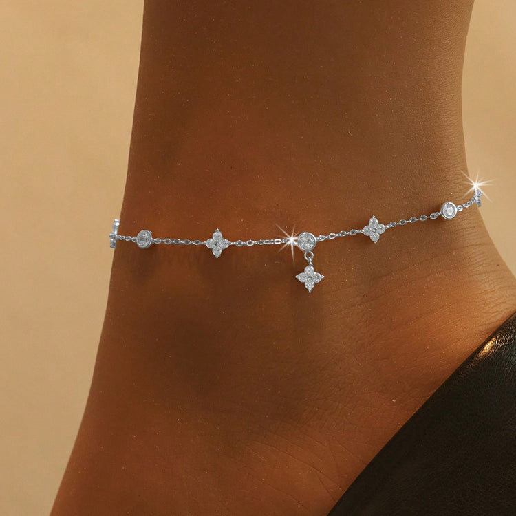 Sterling silver clover and star charm anklet worn on ankle, silver tone