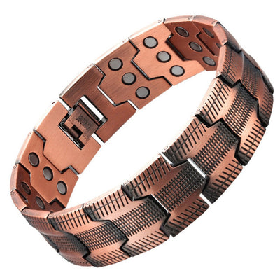 Close-up view of ancient red copper magnetic bracelet showing carved wheel pattern link detail