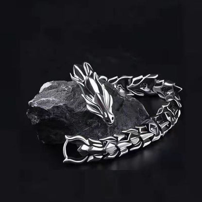 Silver-tone dragon chain bracelet for men on dark stone background
