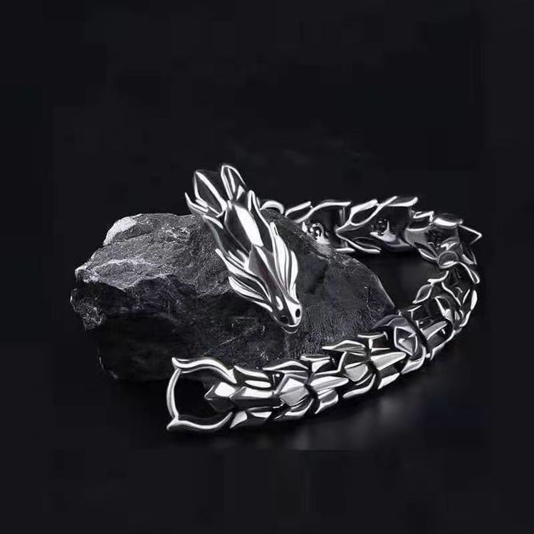 Silver-tone dragon chain bracelet for men on dark stone background