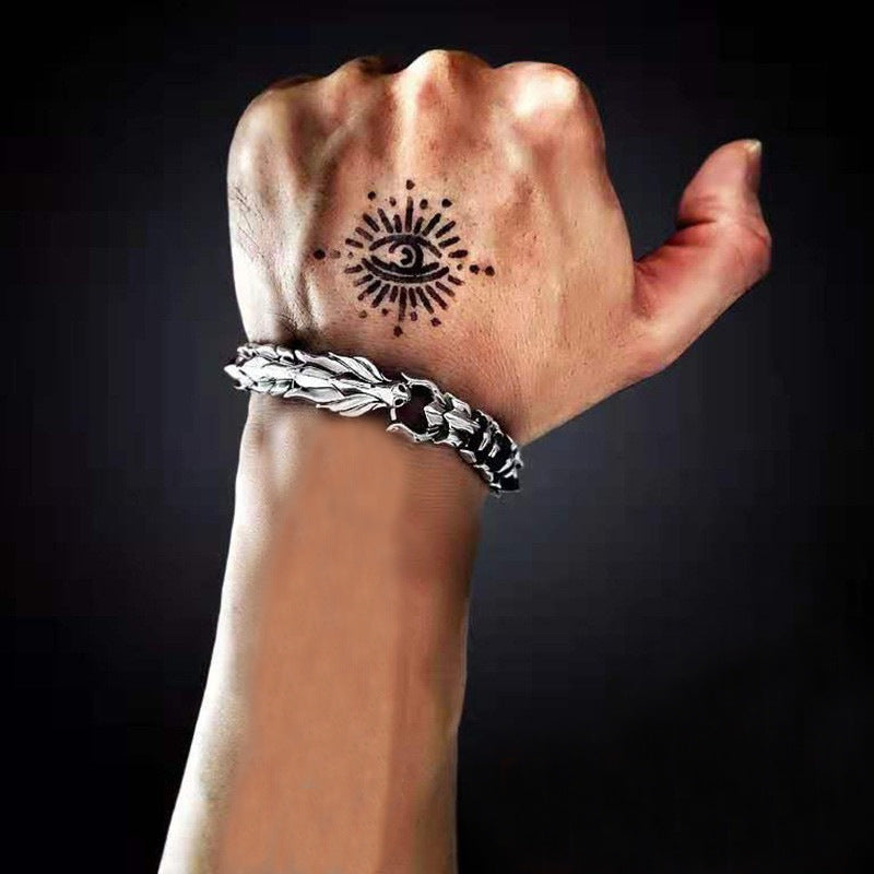 Silver-tone dragon bracelet worn on wrist, close-up
