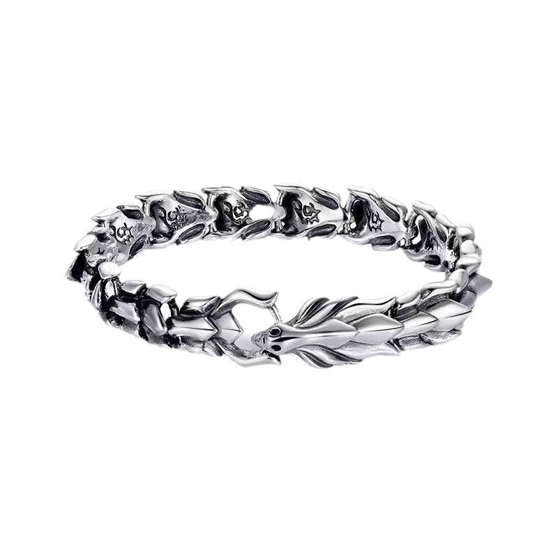 Silver-tone dragon chain bracelet flat lay on white background