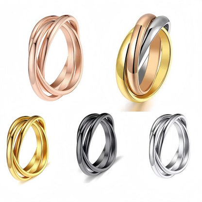 Three interlocked titanium steel rings in rose gold, two-tone gold, black, and silver finishes, group product shot