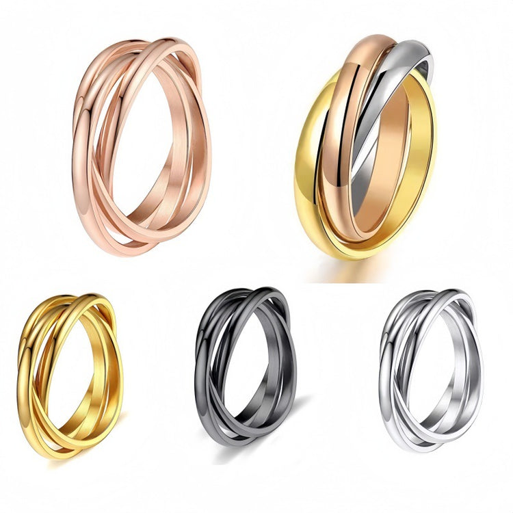 Three interlocked titanium steel rings in rose gold, two-tone gold, black, and silver finishes, group product shot