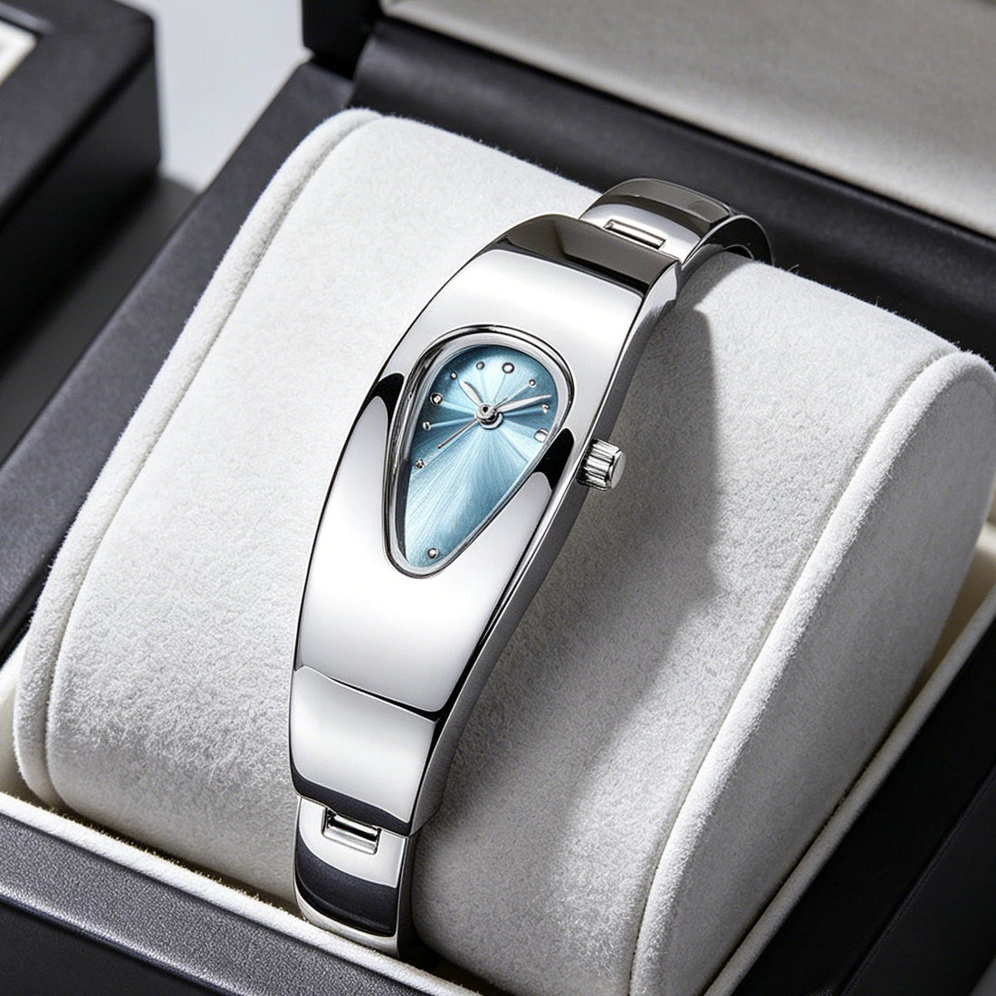 Silver stainless steel water drop watch with blue teardrop dial, front view on jewelry cushion