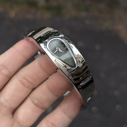 Black dial water drop watch worn on wrist, outdoor close-up