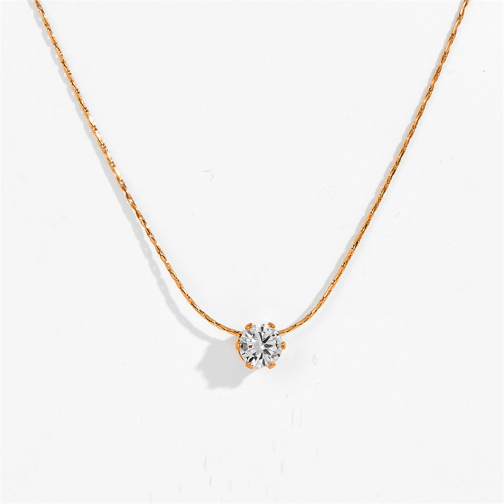 Gold-tone six claw pendant necklace with clear stone pendant, close-up view