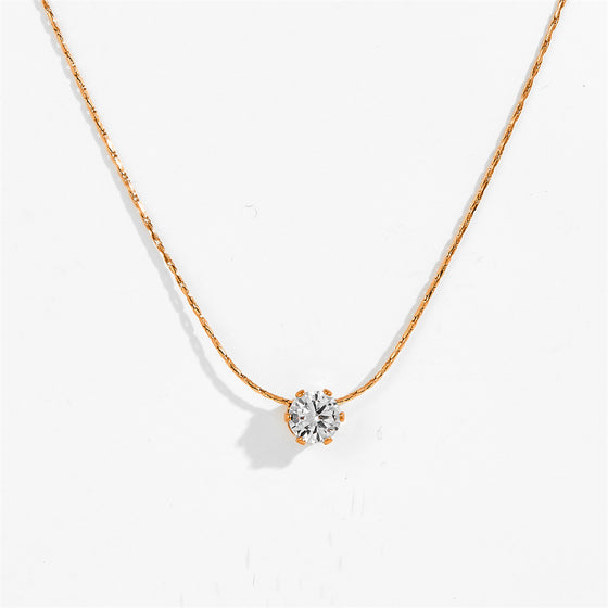 Gold-tone six claw pendant necklace with clear stone pendant, close-up view
