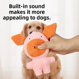 Hand holding a pink corduroy plush pig dog toy with built-in squeaker in front of a golden retriever