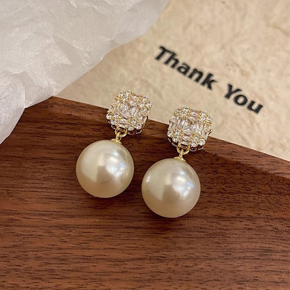 Copper pearl drop stud earrings displayed on gift packaging