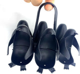 Close-up of penguin egg holder pieces showing the center handle and feet