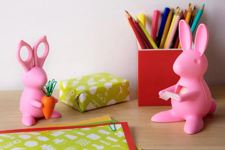 Bunny-shaped desk organizer figurine holding scissors as ears and a carrot-shaped paper clip holder in its paws